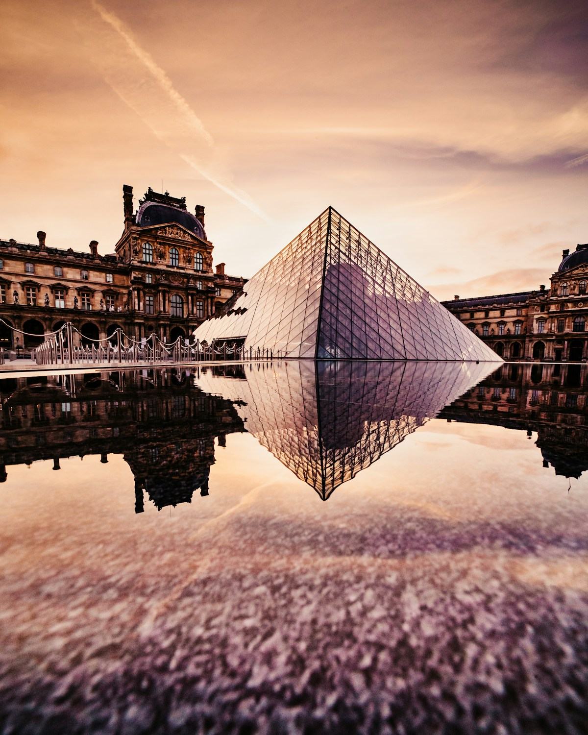 Morning light over the glass pyramid and courtyard of the Louvre in Paris.