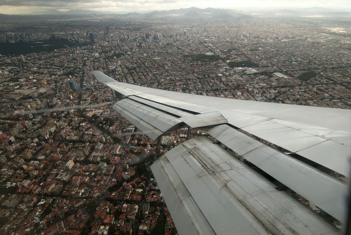 An airplane-window view over Mexico City while approaching Benito Juarez International Airport.