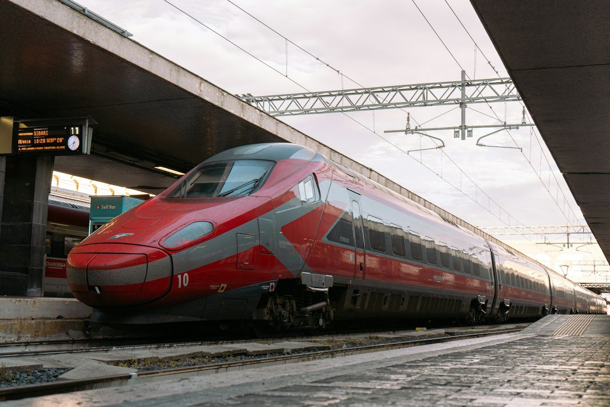 A red high-speed train at Roma Termini station in Rome.