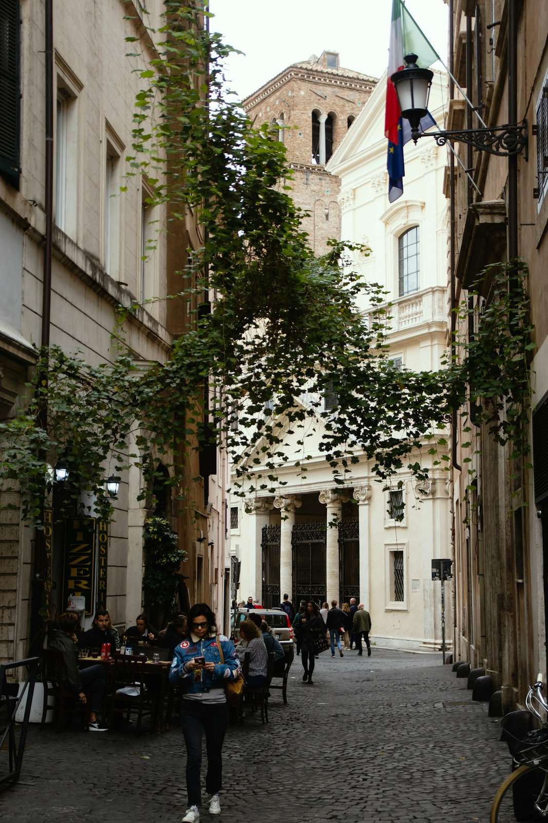 A narrow, plant-lined street in the historic centre of Rome.