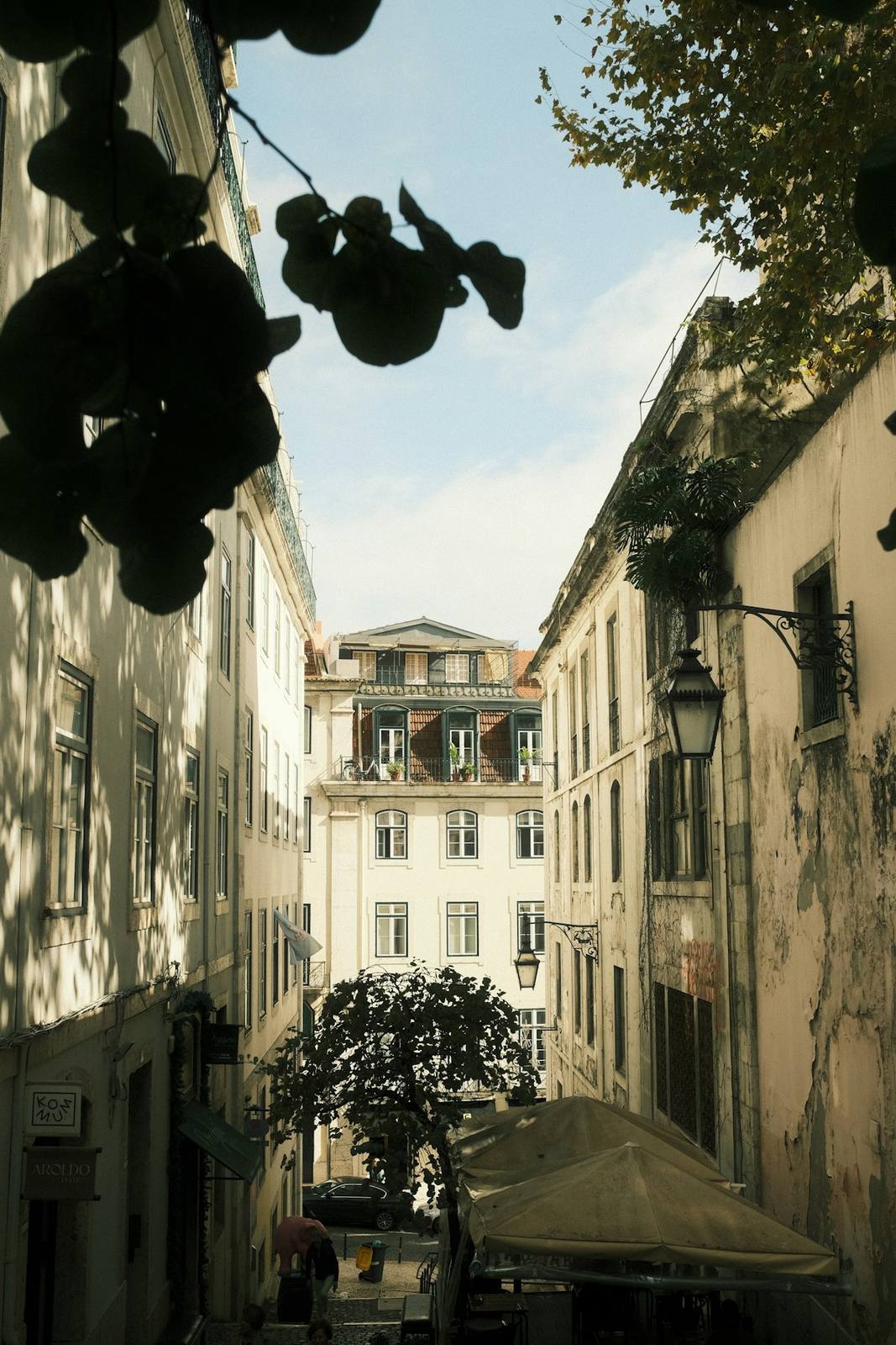 A narrow Lisbon street lined with pastel facades and balconies.
